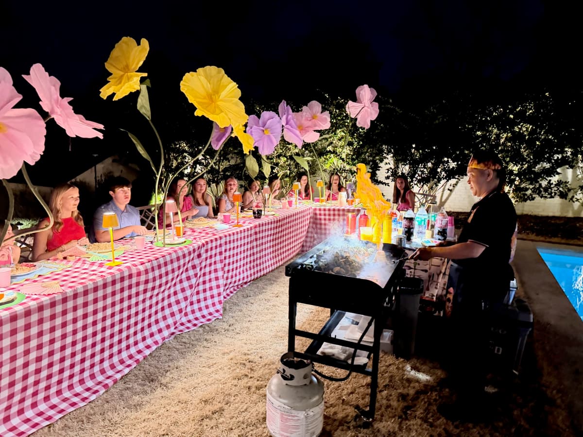 Kids hibachi party at night with decorated table and chef